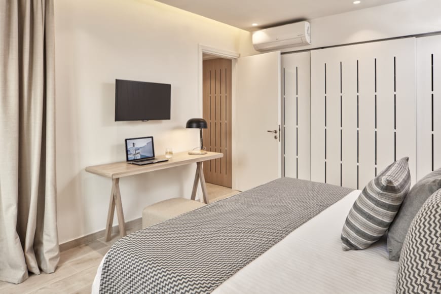 a bed with a desk and a television in a room