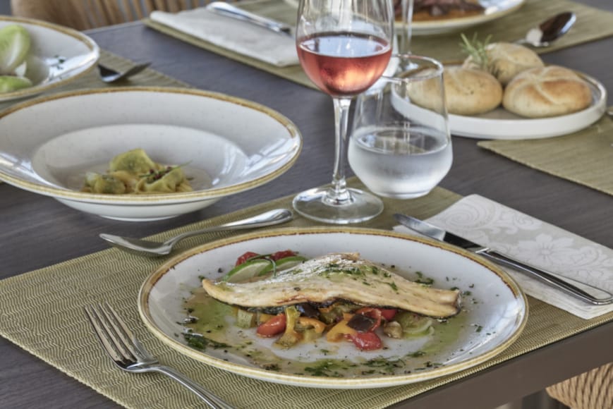 a plate of food and a glass of wine on a table