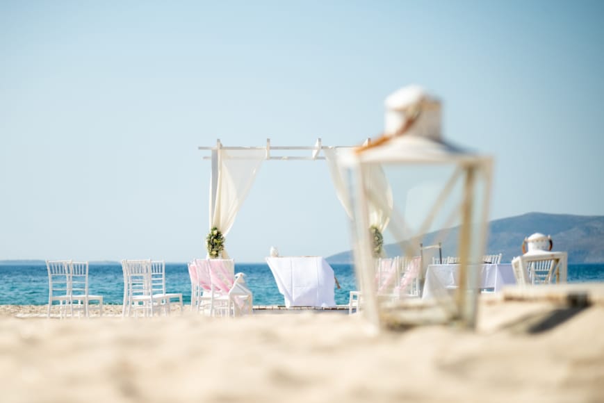 a couple of people in white suits on a beach