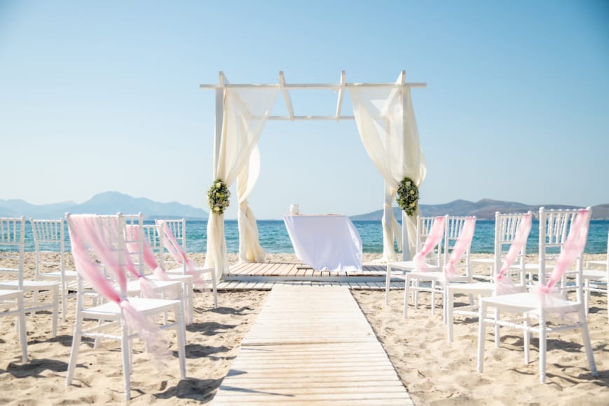 a row of pink chairs on a beach