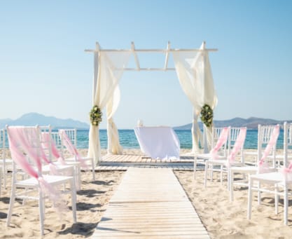 a row of pink chairs on a beach