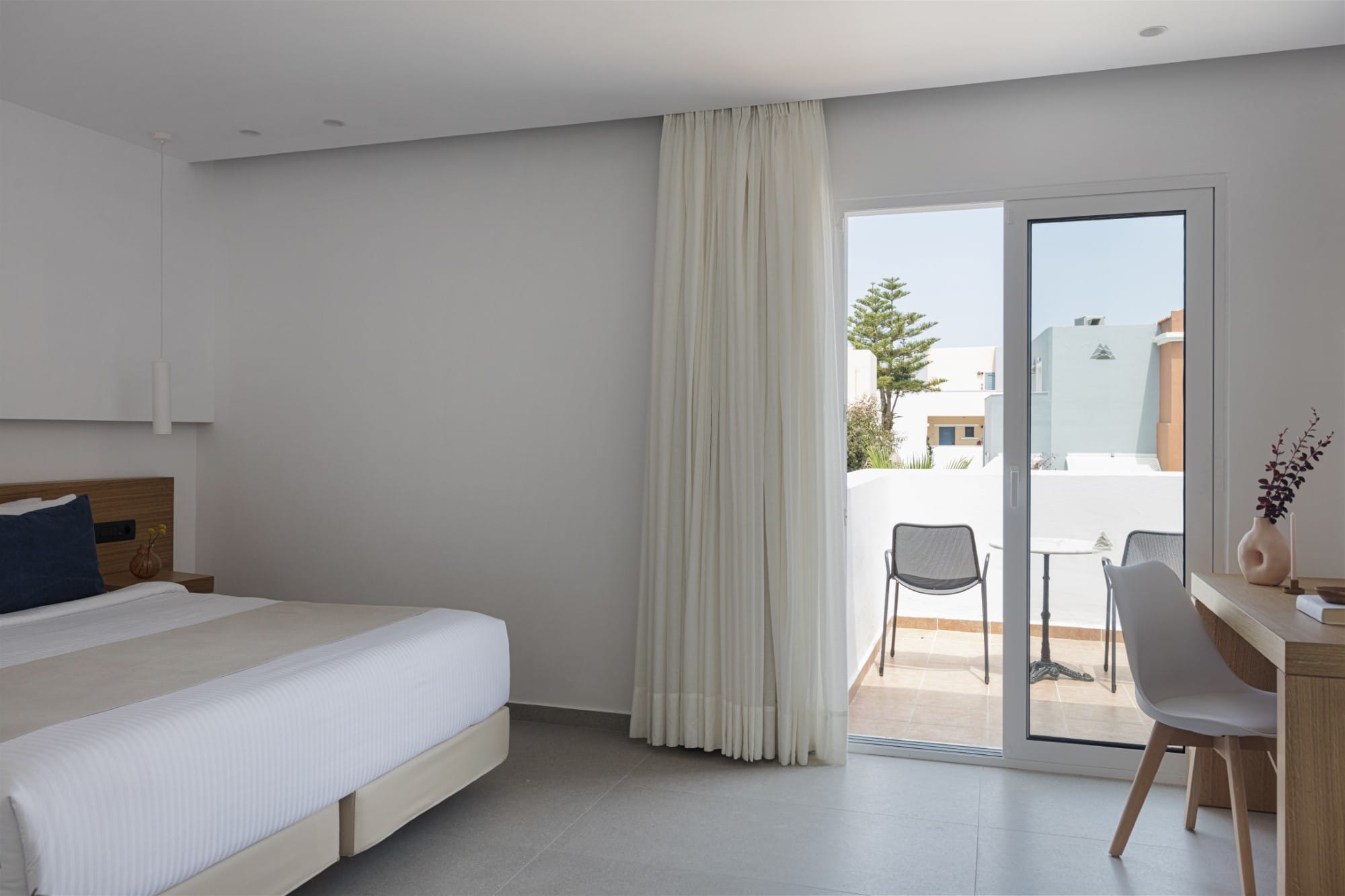 a room with a bed and chairs