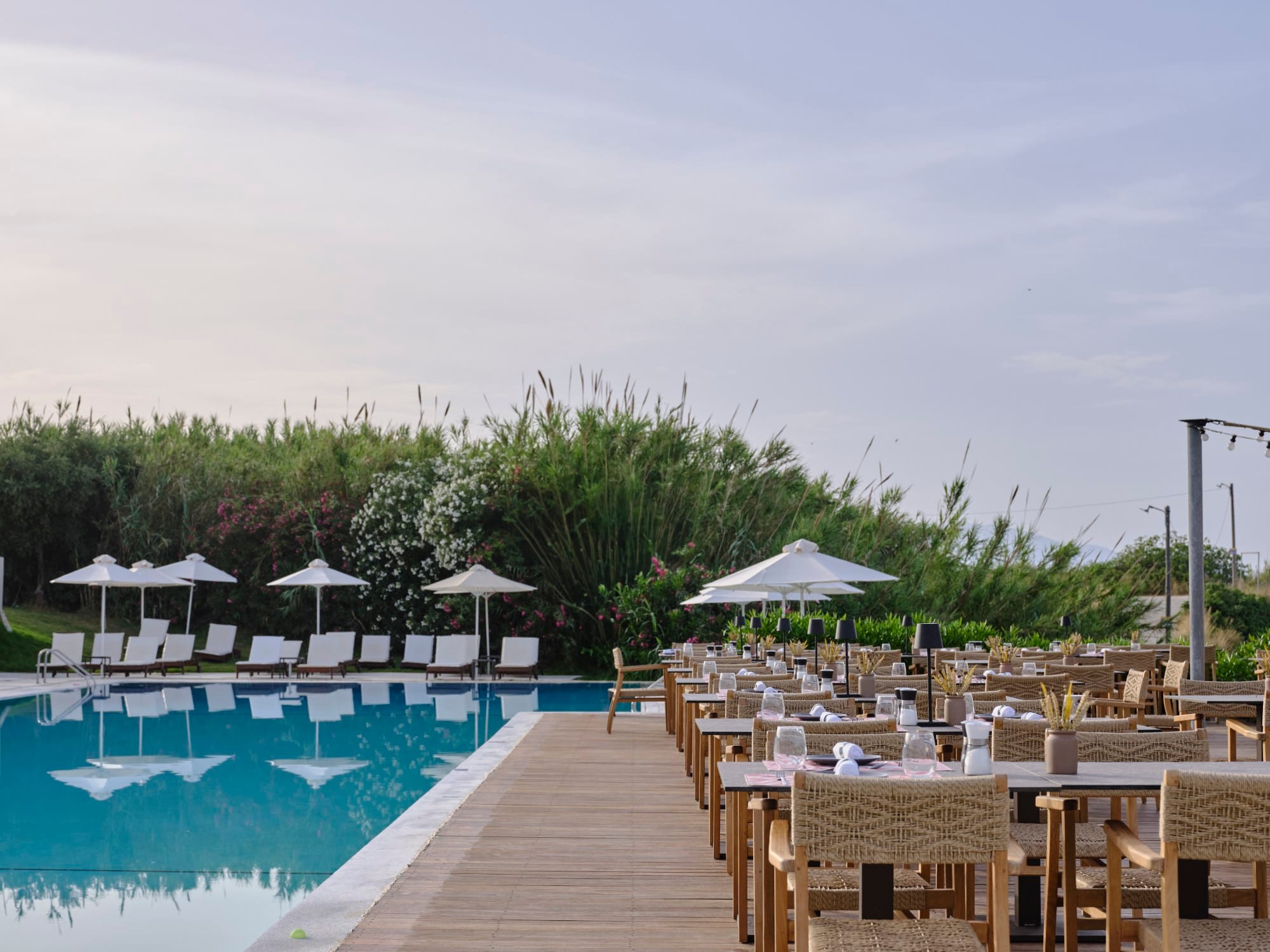 a pool with tables and chairs next to it