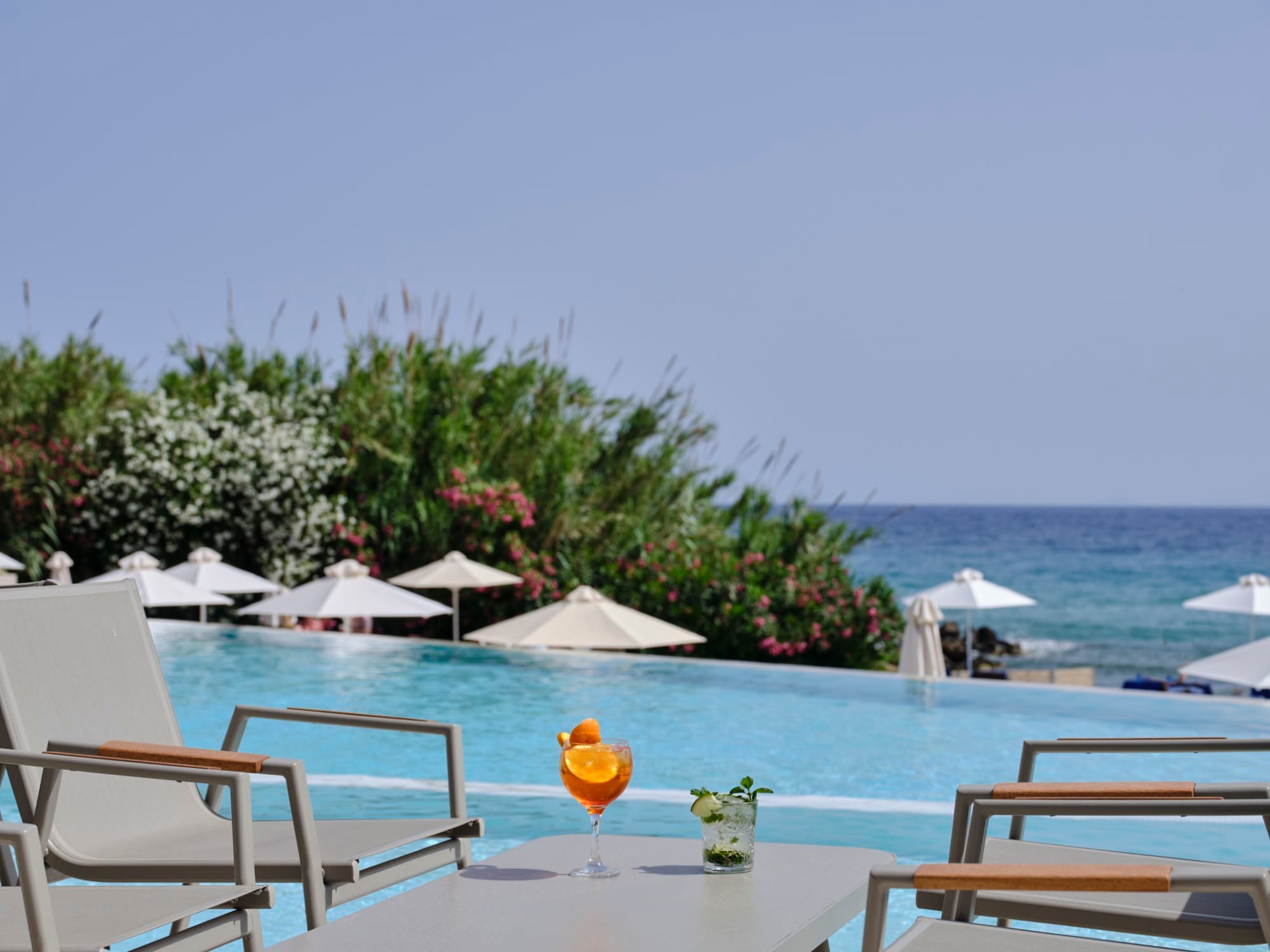 a table with chairs and umbrellas by a beach