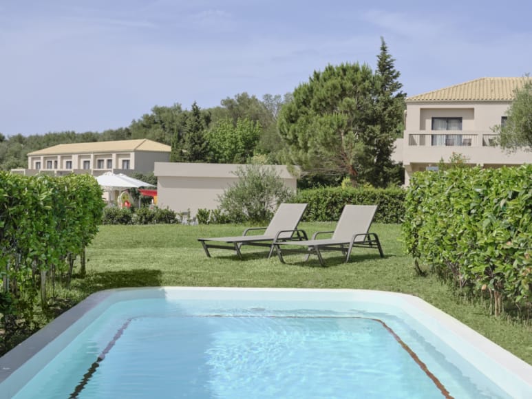 a pool with chairs and a table by it