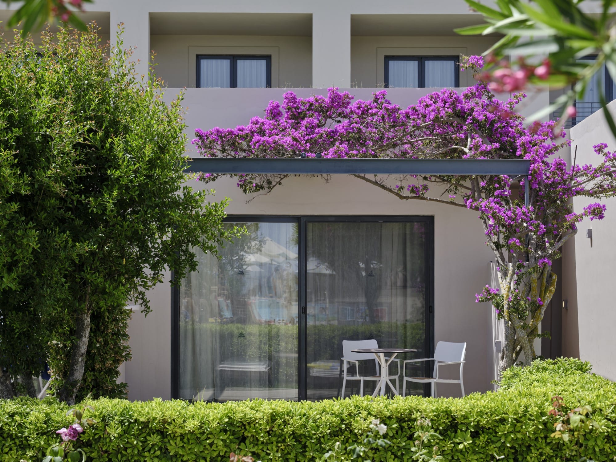 a building with a glass door and chairs in front of it