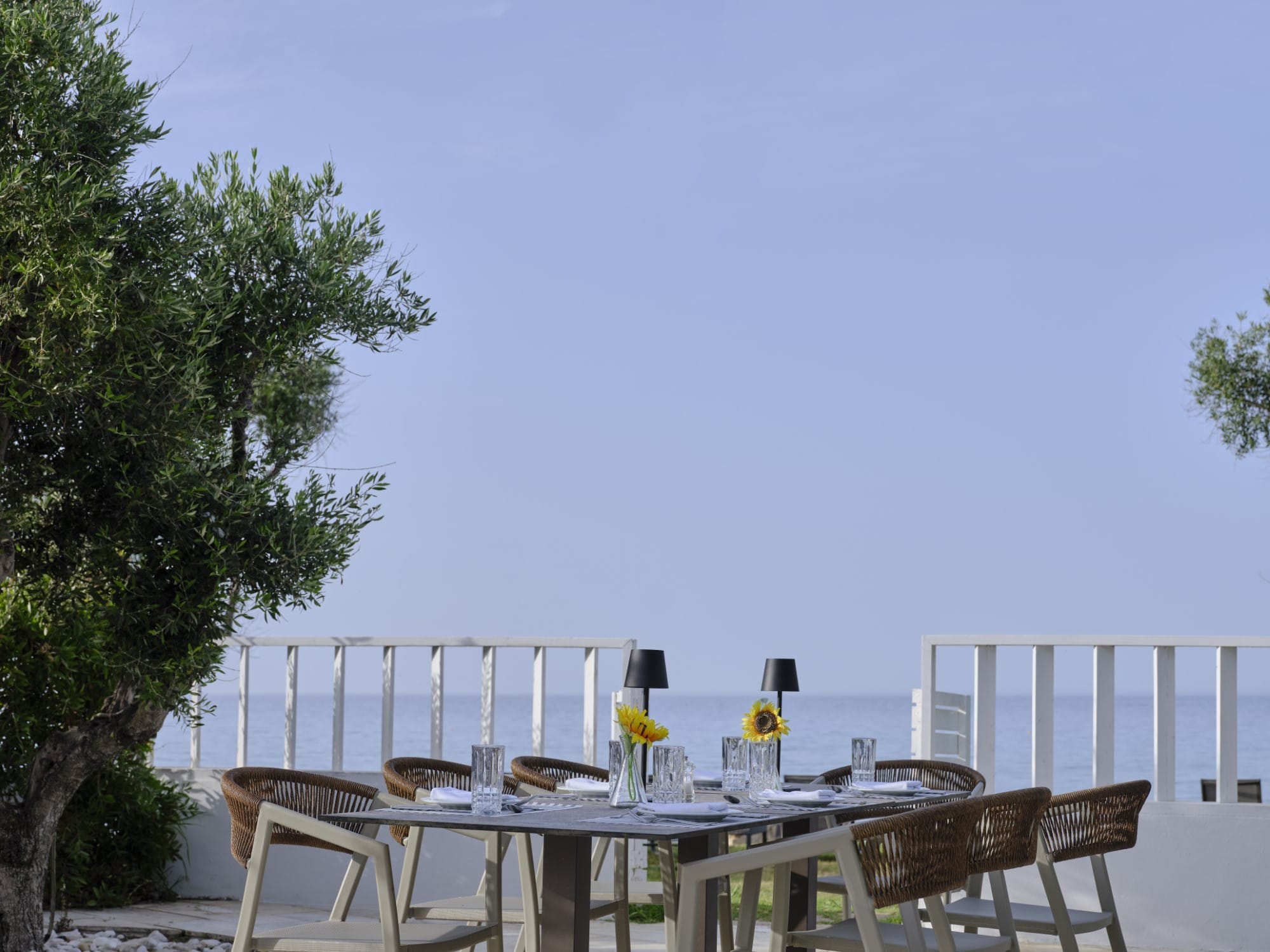 a table with glasses and plates on it on a deck