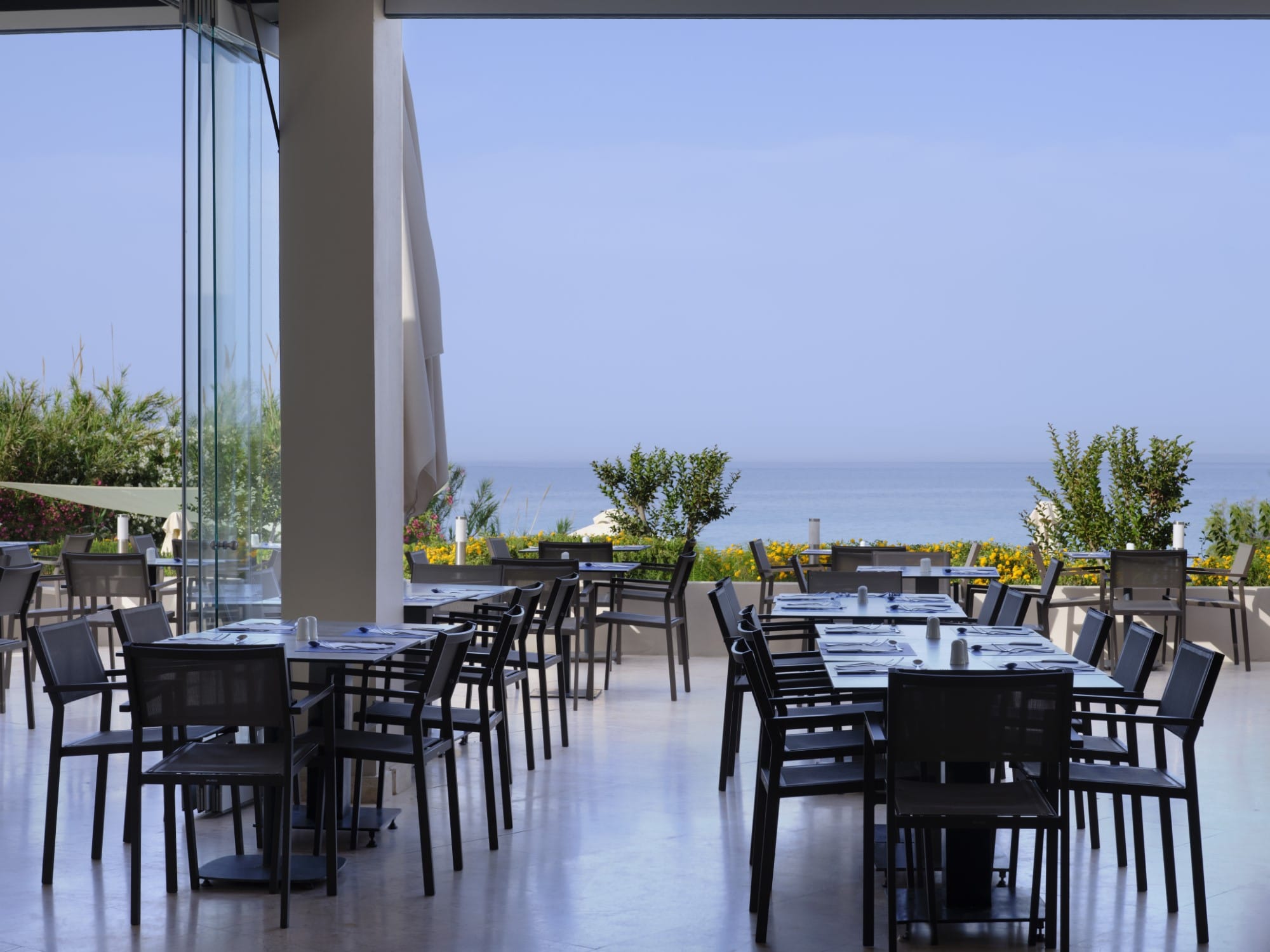 a group of tables and chairs on a deck overlooking a body of water