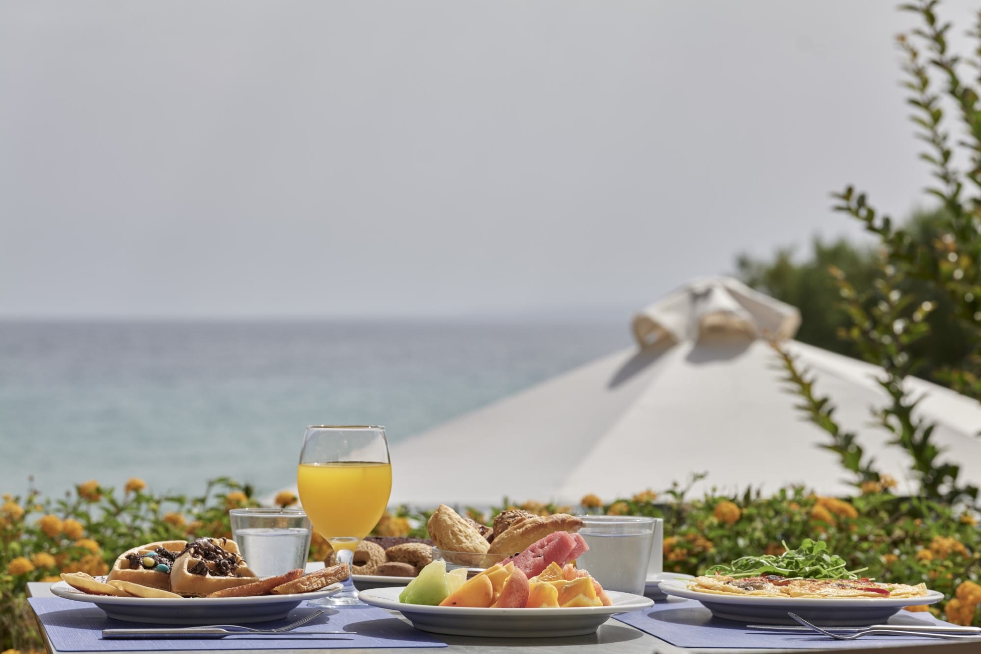 a table with food and drinks on it by a body of water