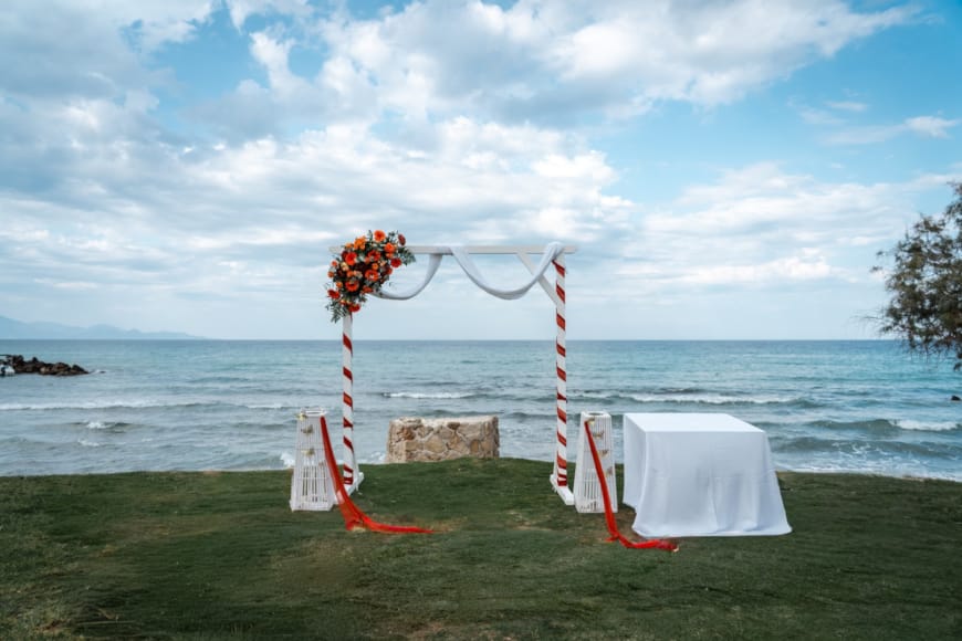 a table and chairs on a lawn by the water