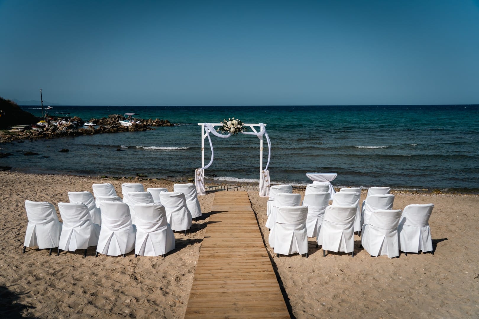 a group of white chairs on a beach