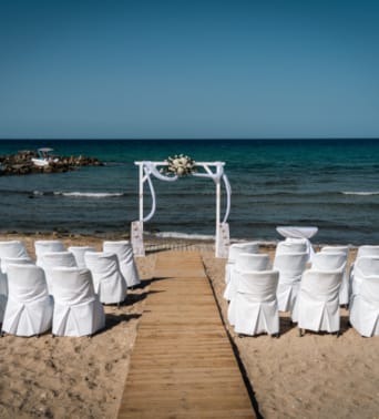 a group of white chairs on a beach