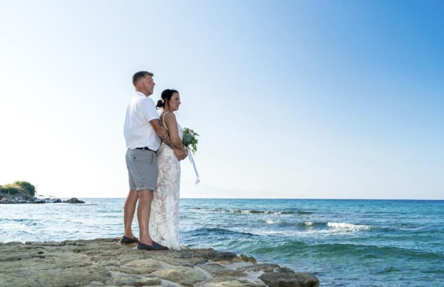 a man and woman kissing on a beach