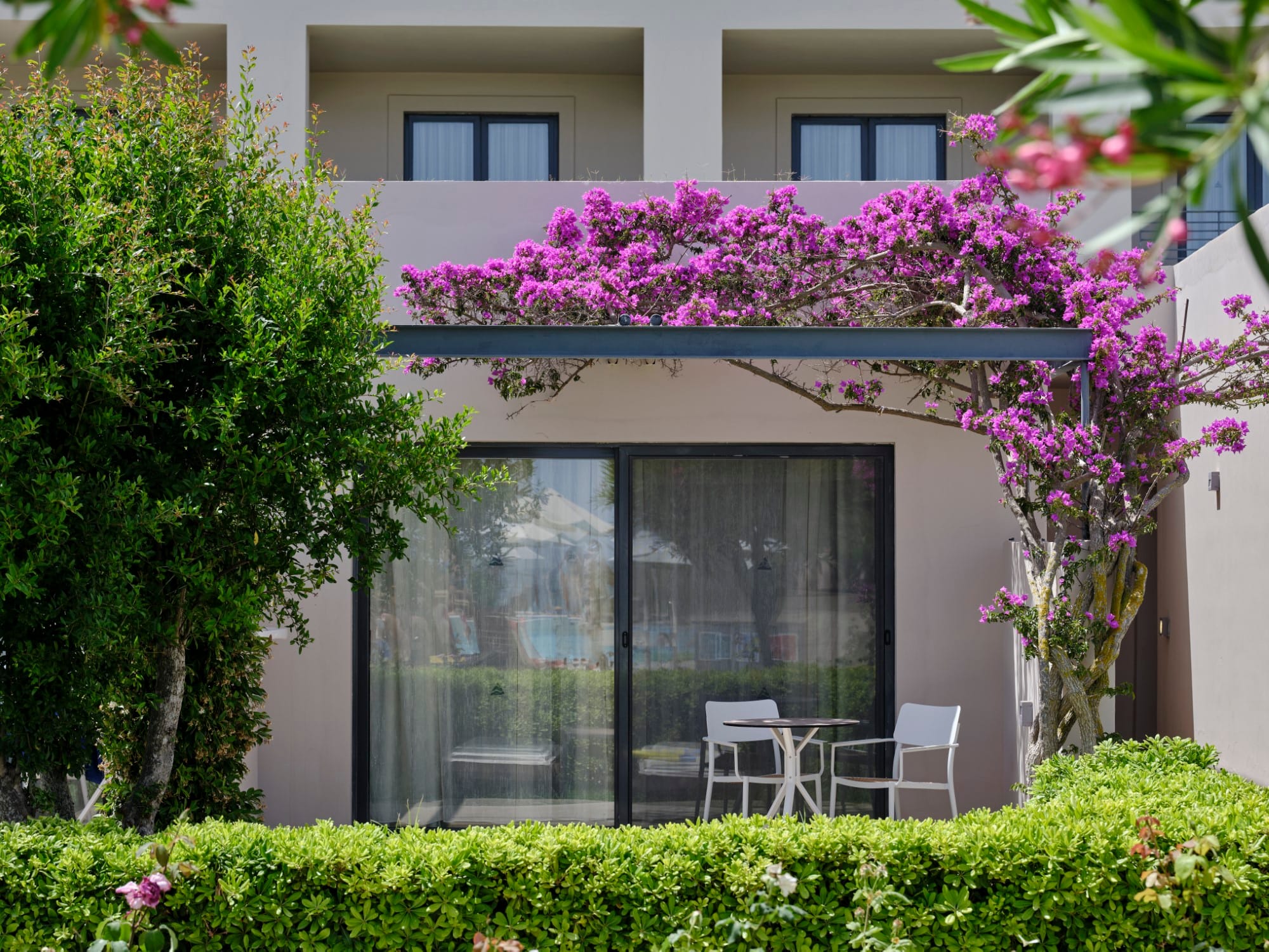 a building with a glass door and chairs in front of it