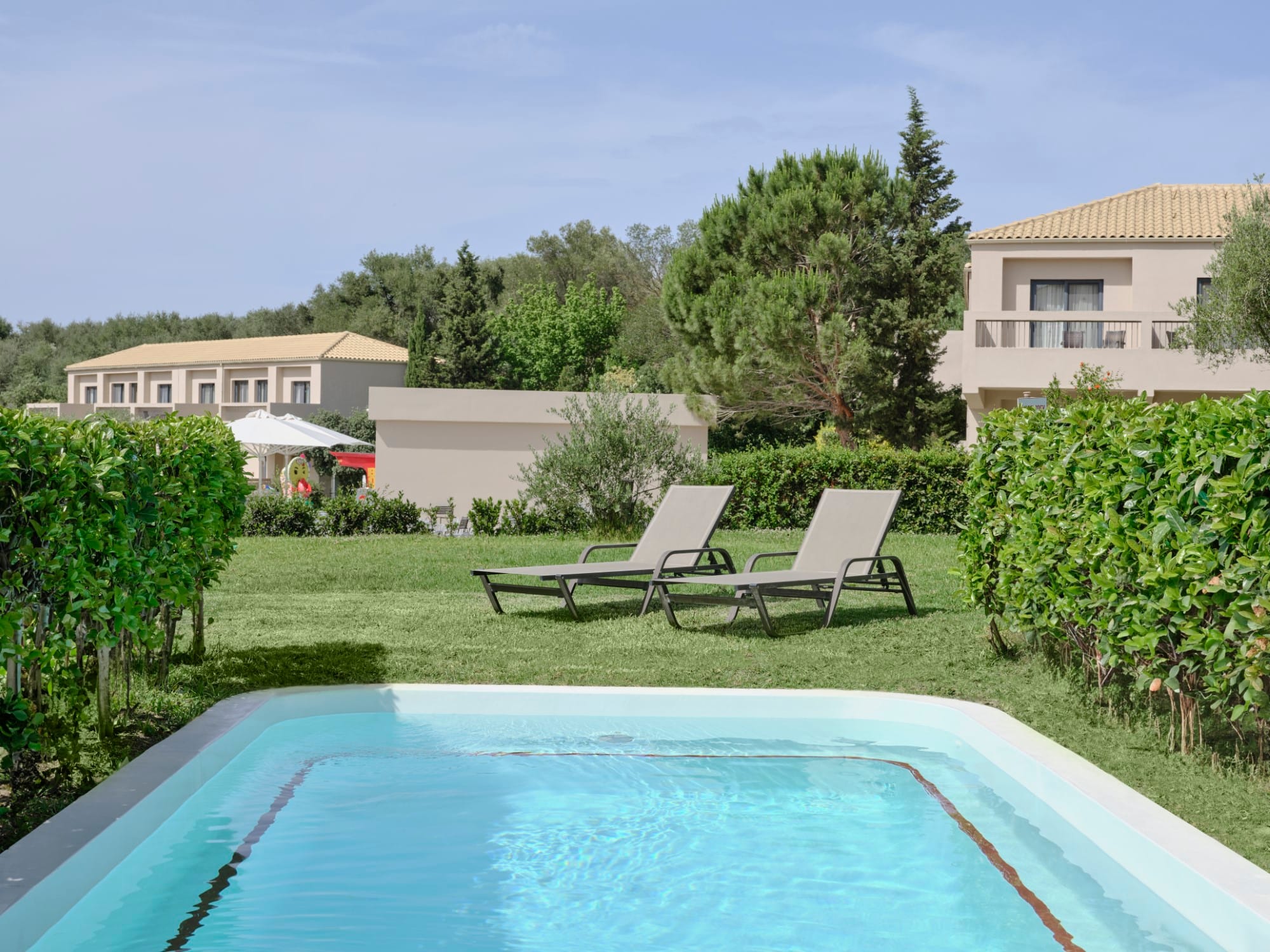 a pool with chairs and a table by it
