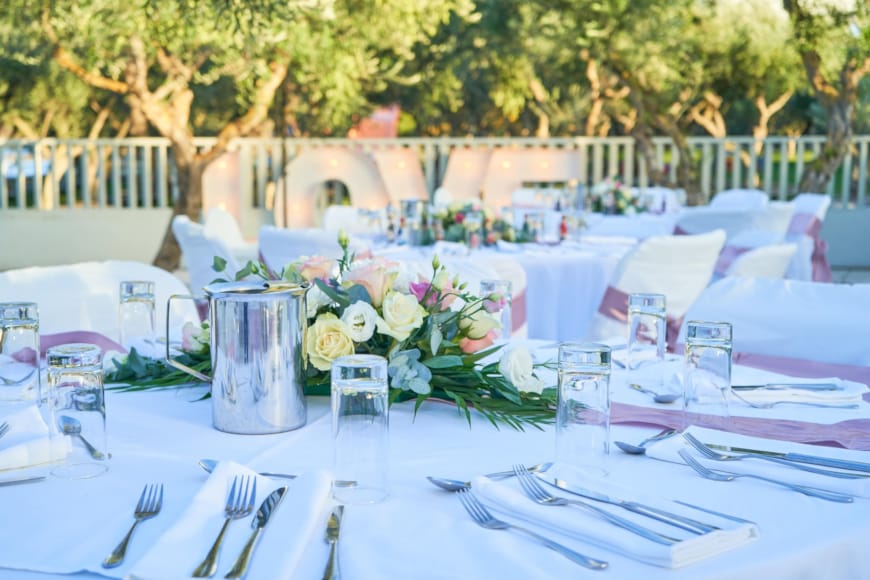 a table set with white tables and white chairs