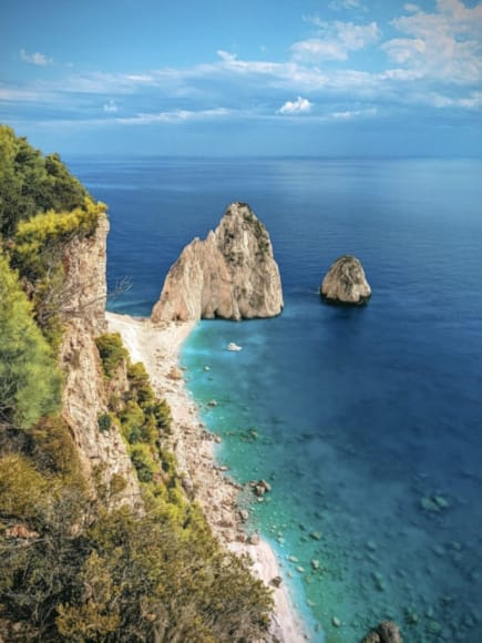 a rocky beach with a large body of water in the background