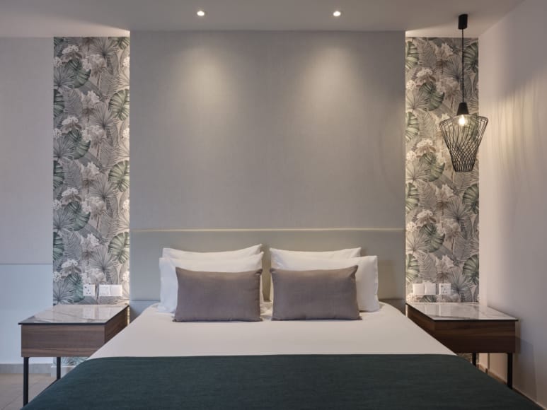 a bed with a large wall of art