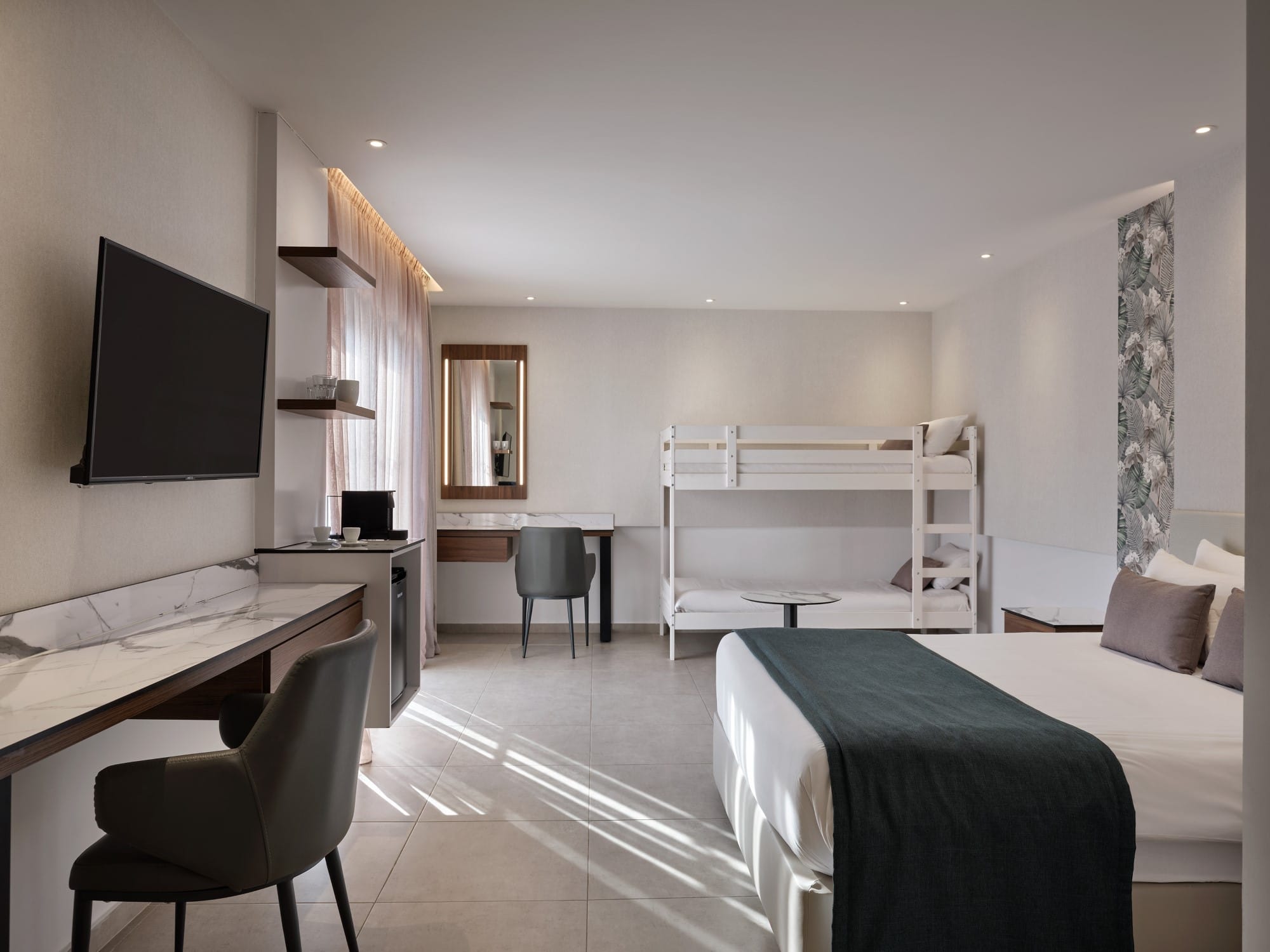 a room with a bed desk and a tv