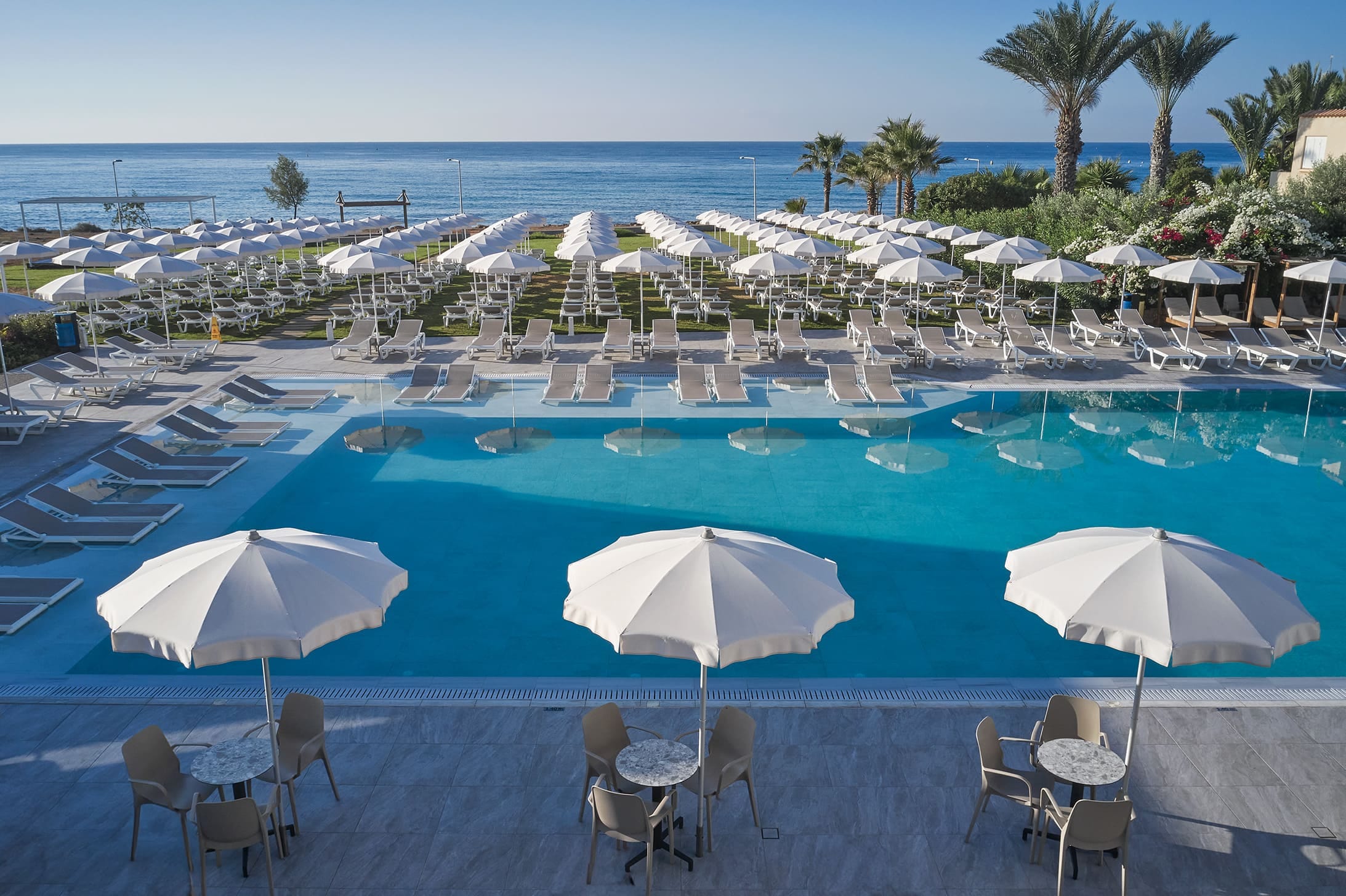 a pool with chairs and umbrellas by it