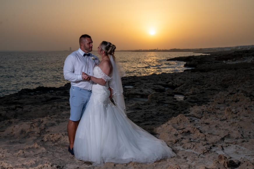 a man and woman posing for a picture on a beach