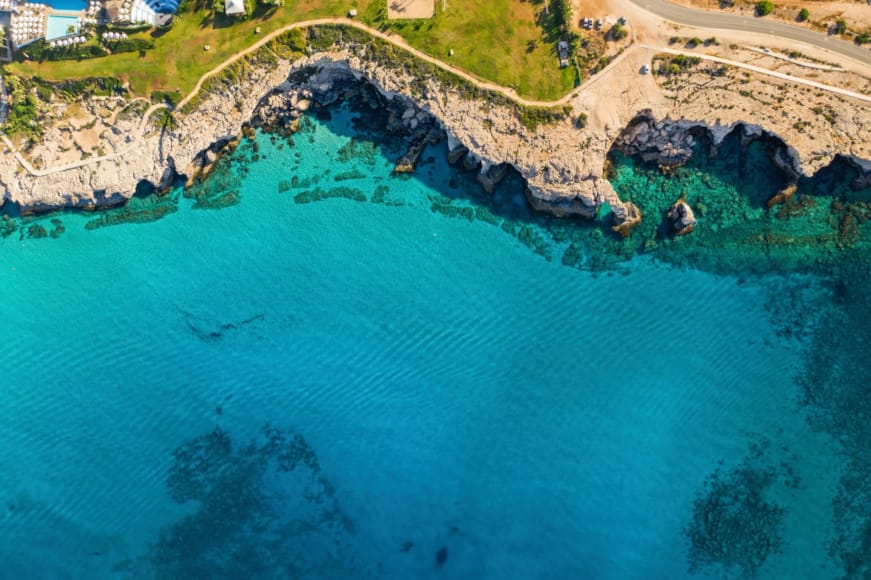 a body of water with rocks and grass around it