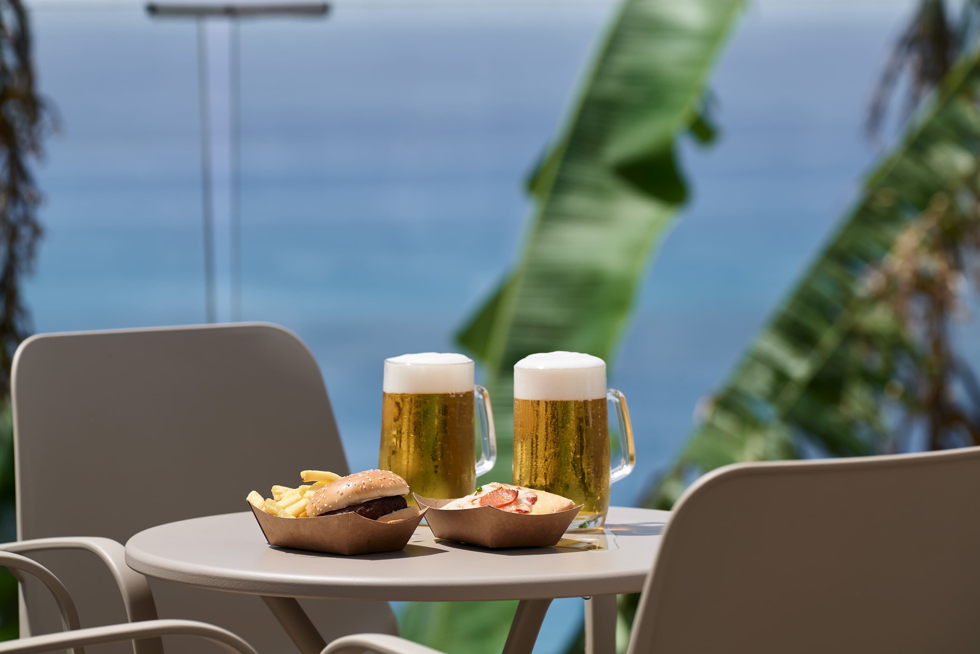 a table with glasses of beer and a plate of food on it