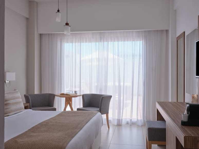 a bedroom with a bed and chairs