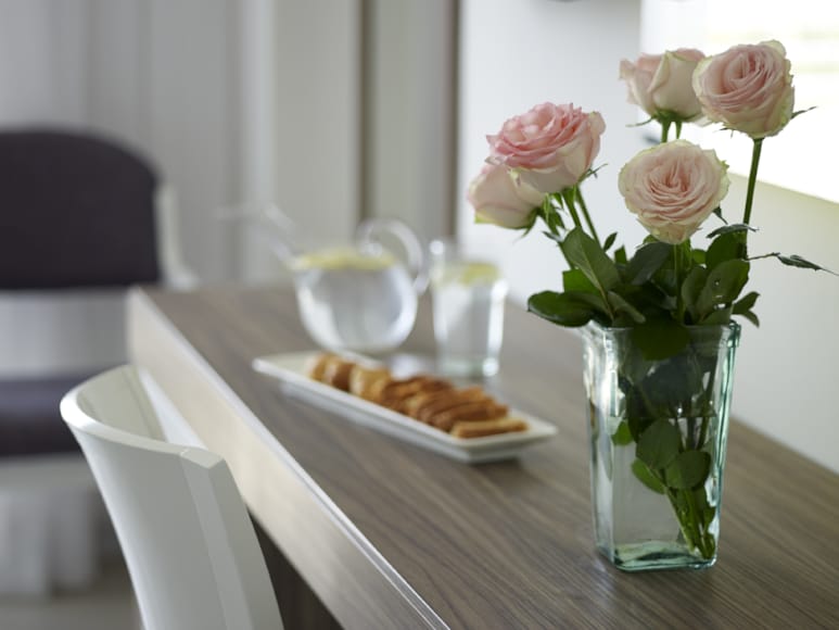 a table with a vase of flowers and a plate of food