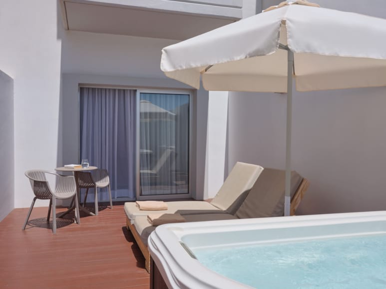 a pool and lounge chairs in a room with a large window