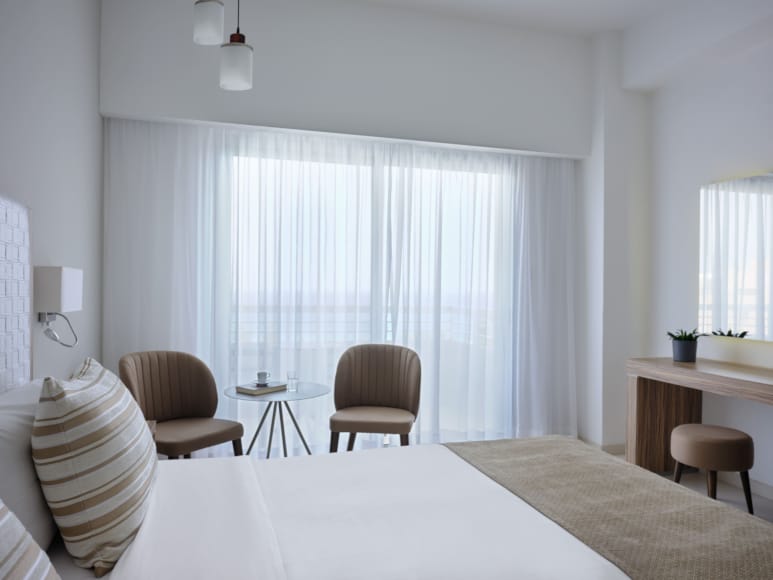 a room with a bed and chairs