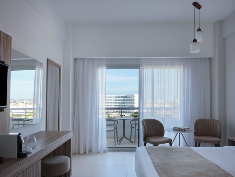 a room with a table chairs and a window with a view of the city
