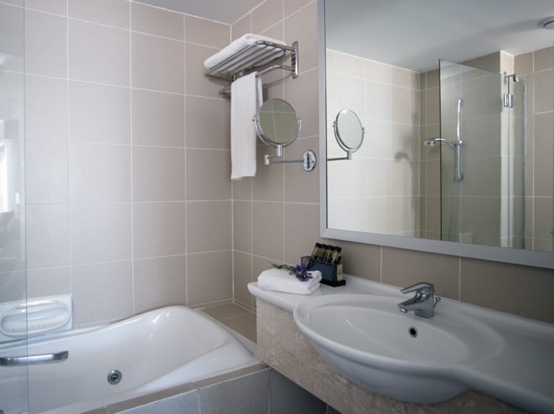 a bathroom with a tub sink and mirror