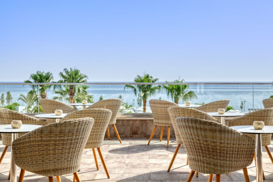 a group of tables and chairs on a deck overlooking the ocean