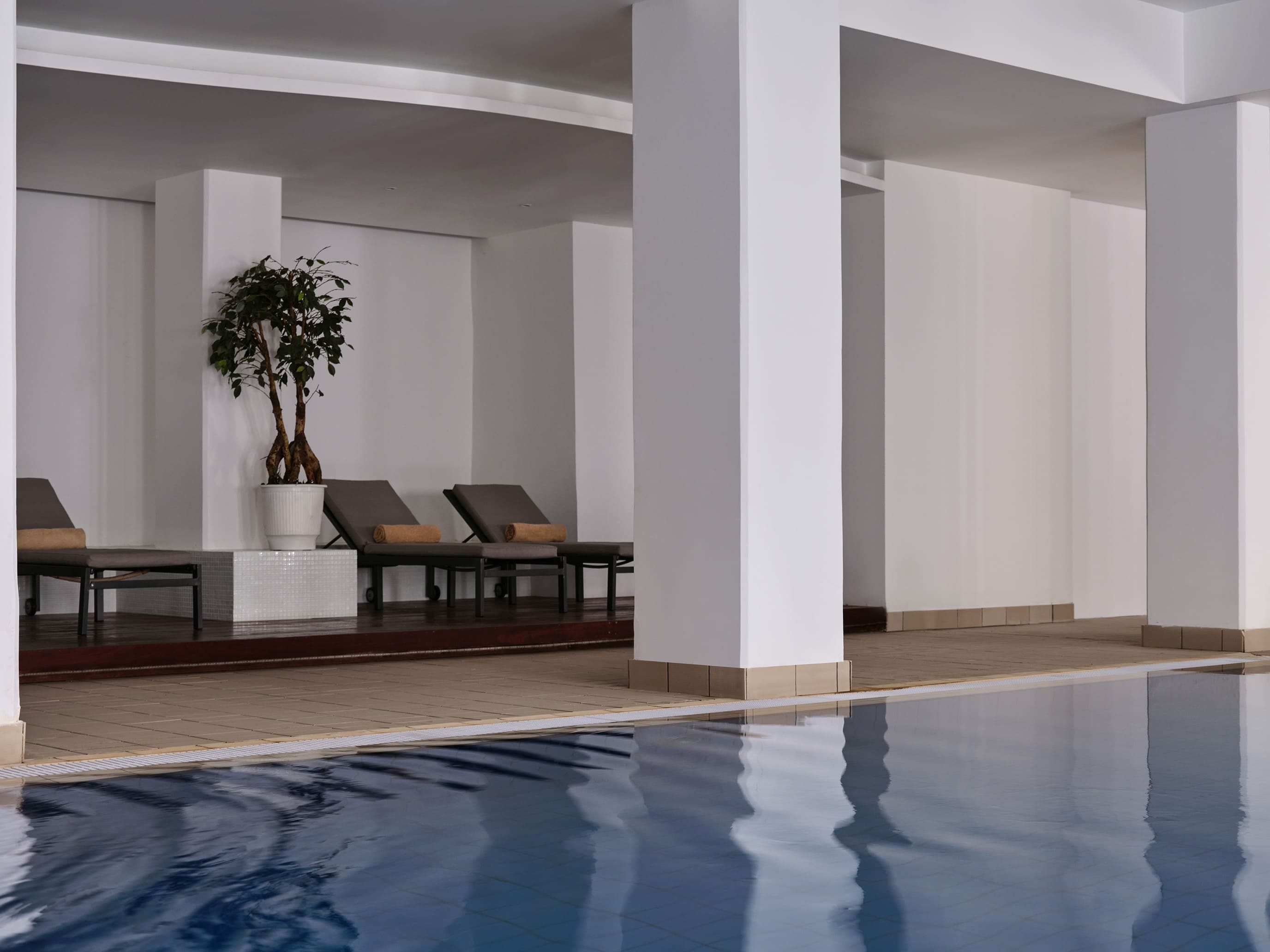 a large room with a pool and chairs