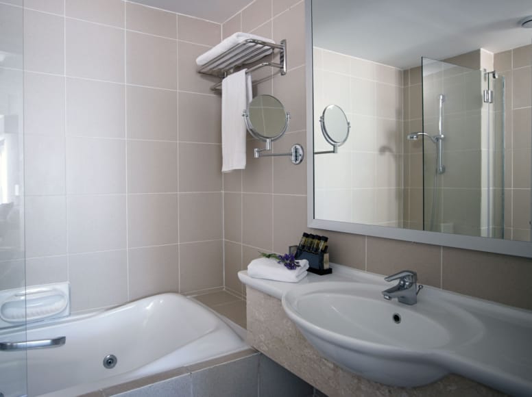 a bathroom with a tub sink and mirror