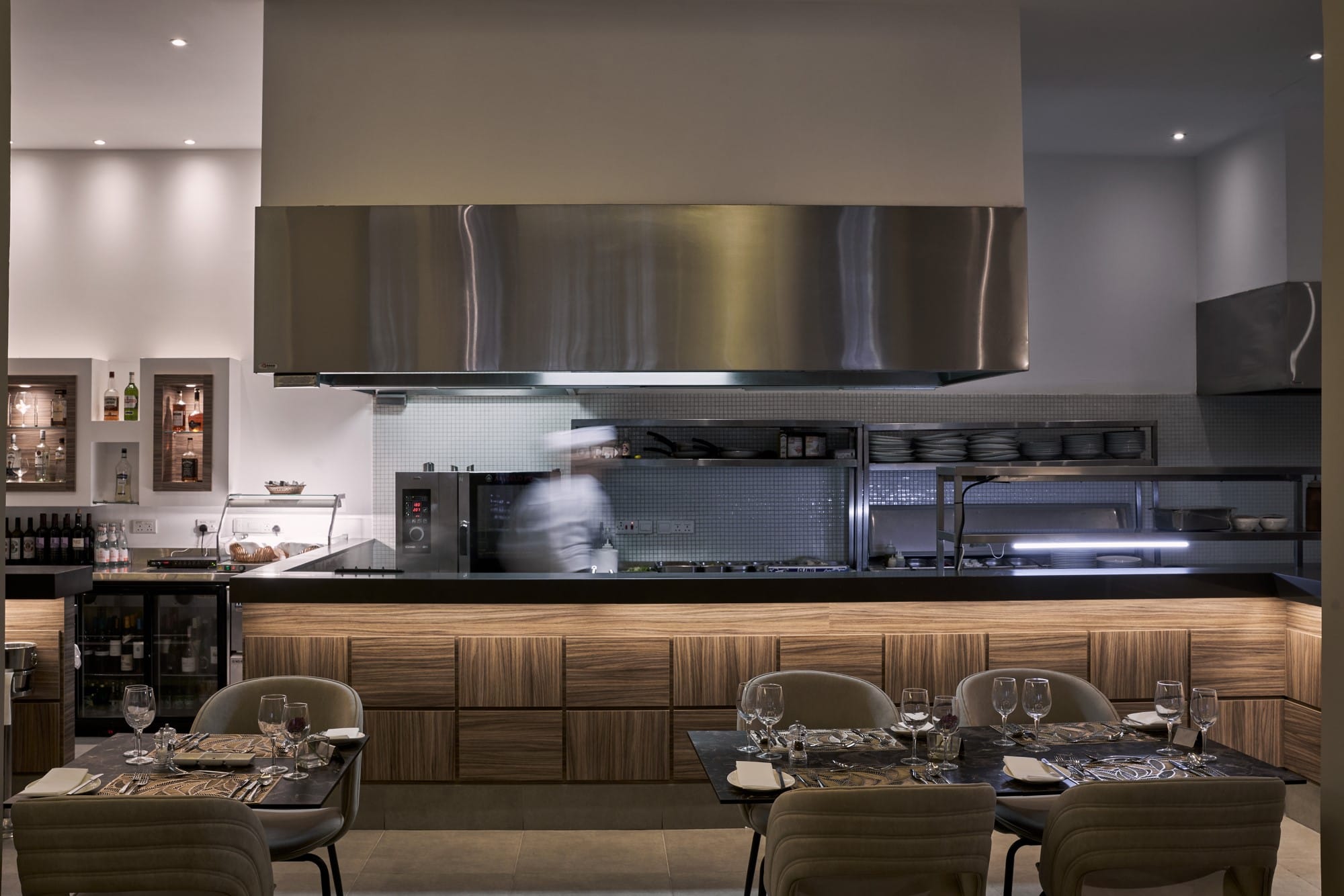 a large kitchen with a bar and chairs