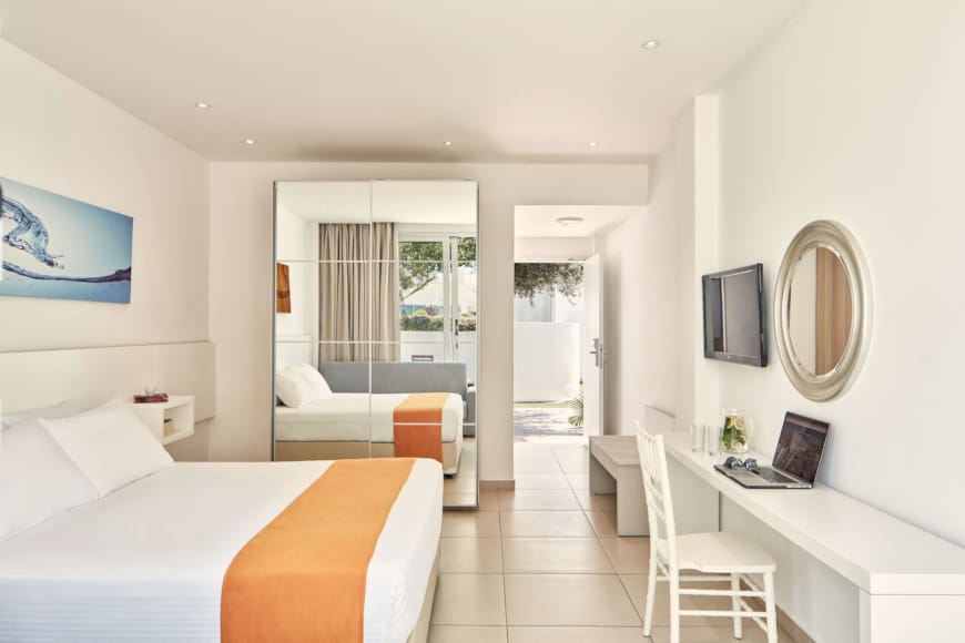 a bedroom with a bed desk and a tv