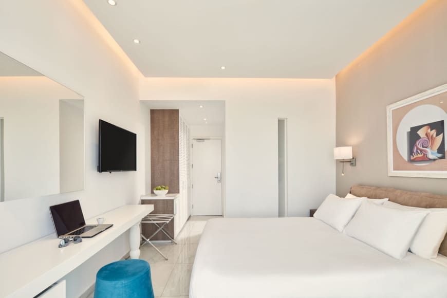 a bedroom with a bed and a laptop on a desk
