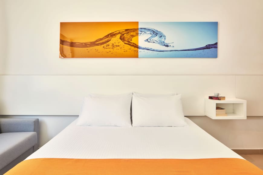 a bed with a painting on the wall
