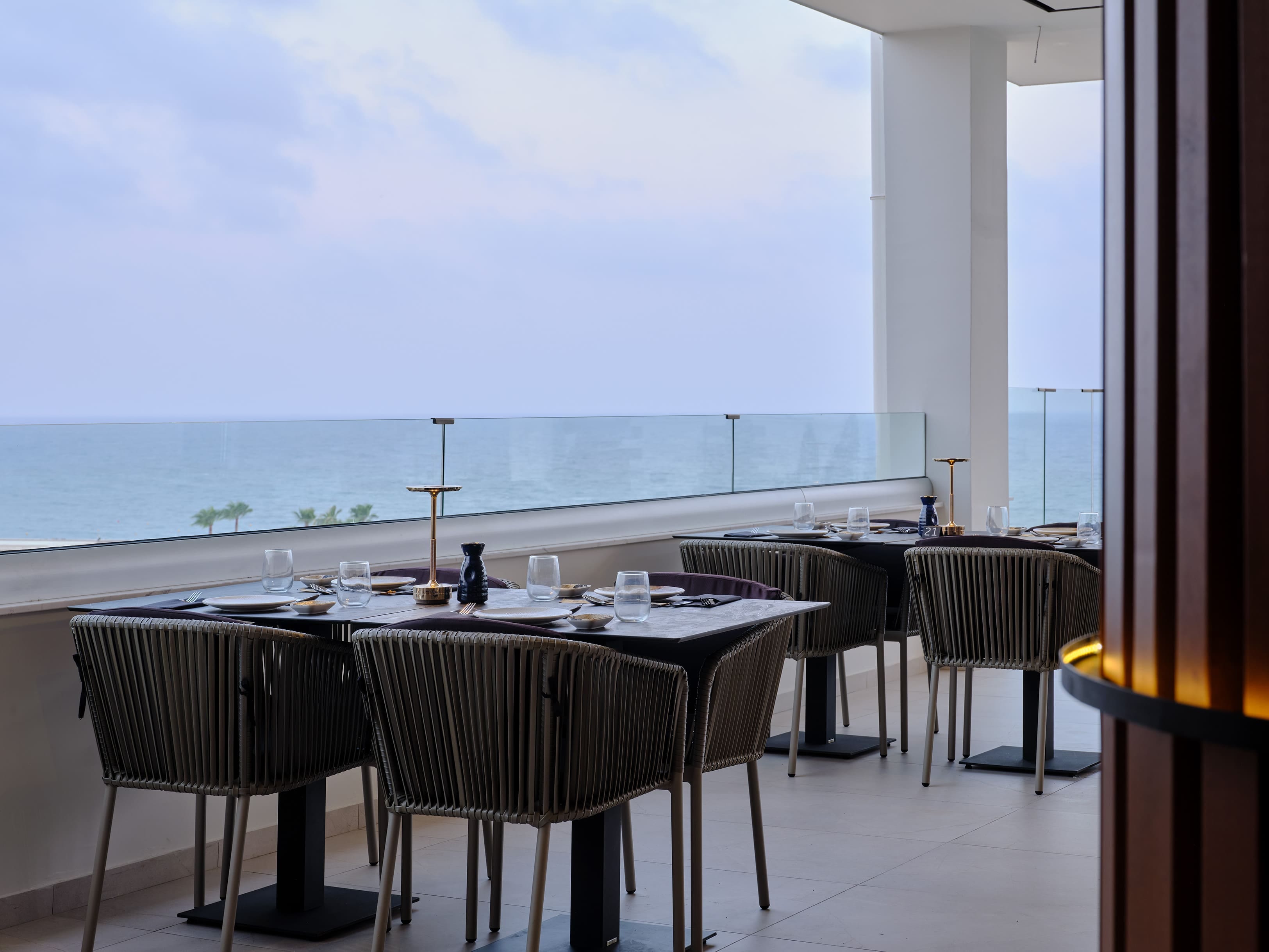 a table with chairs and a view of the ocean
