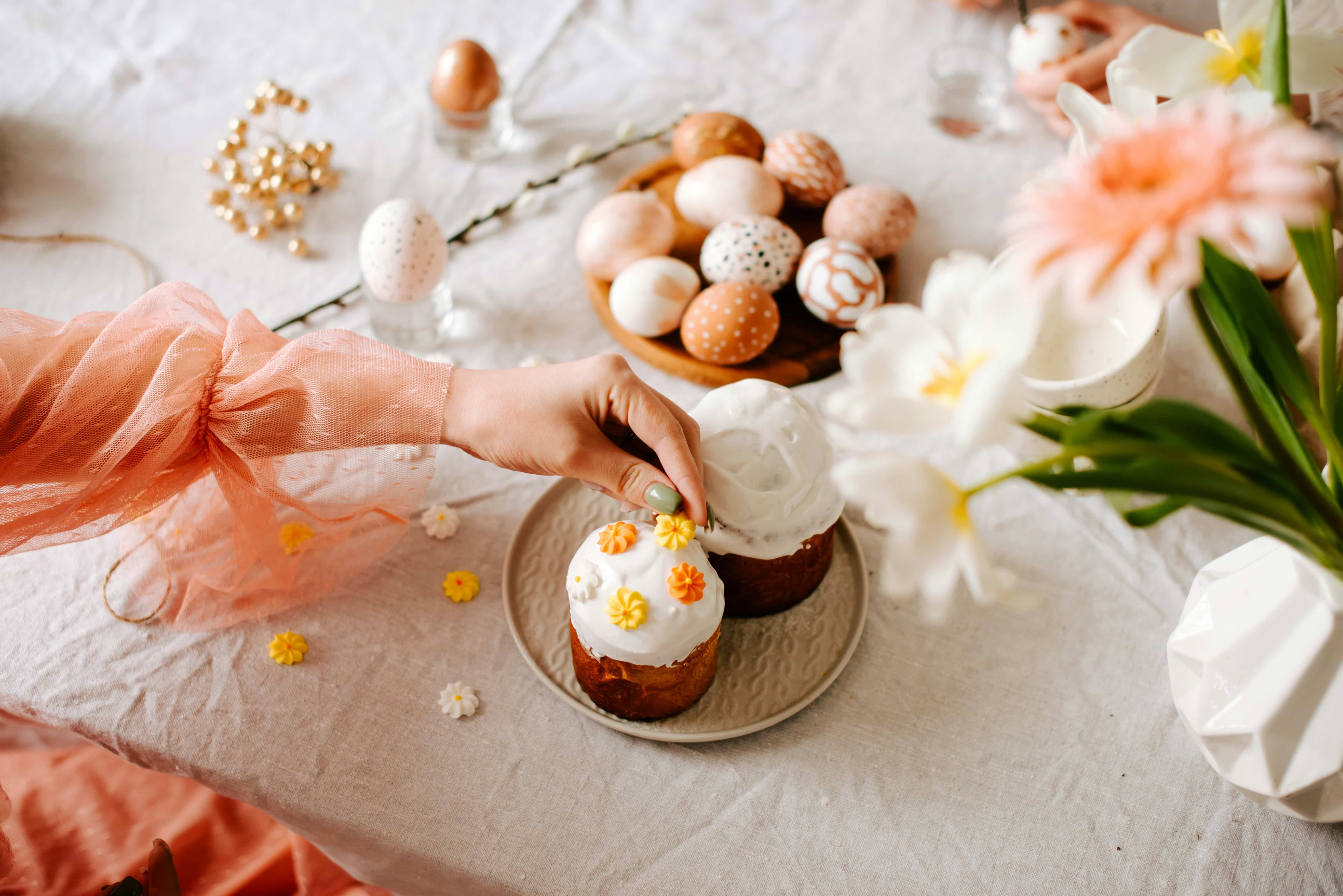 a hand reaching for cupcakes