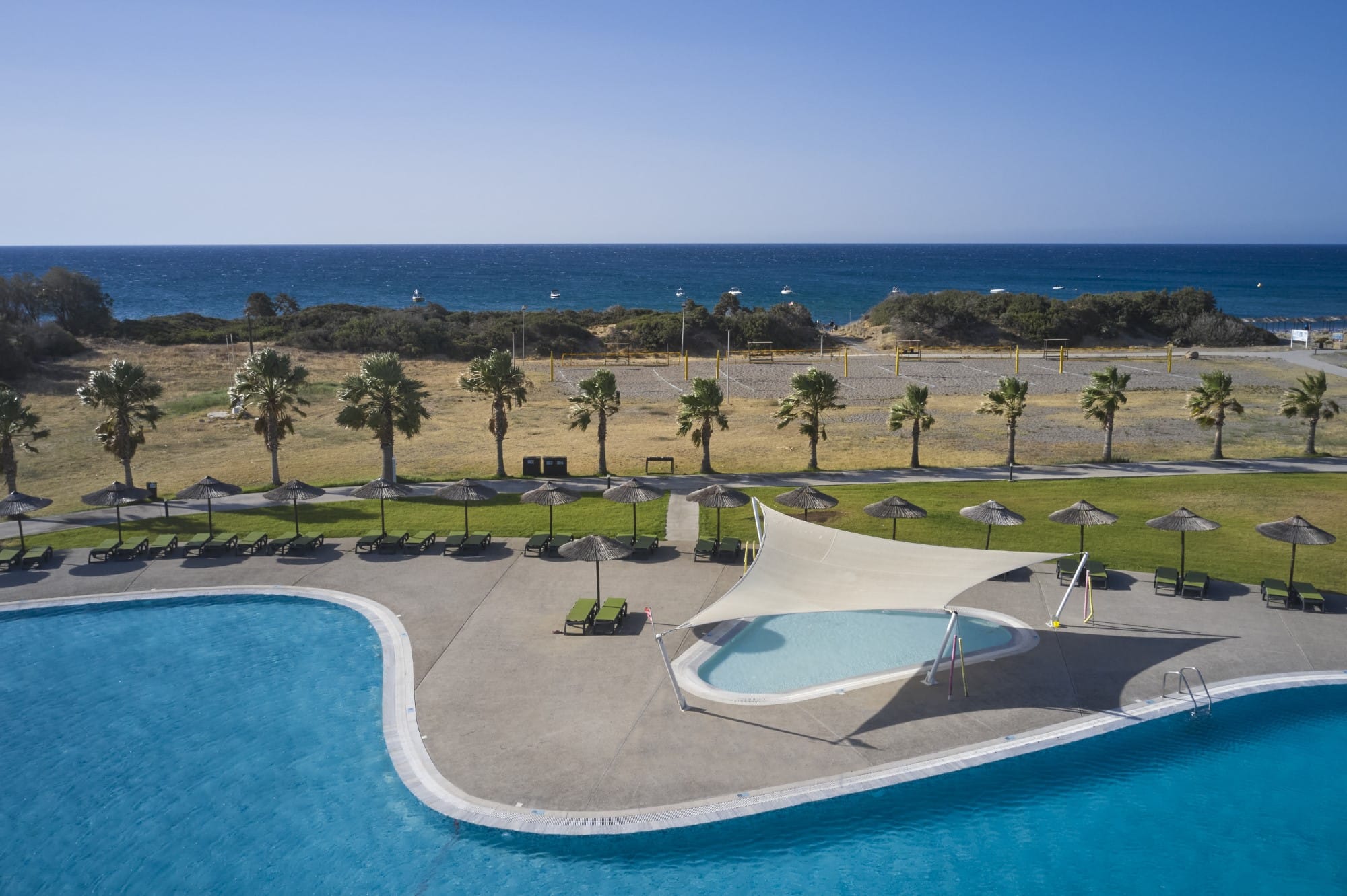 a pool with a beach and trees