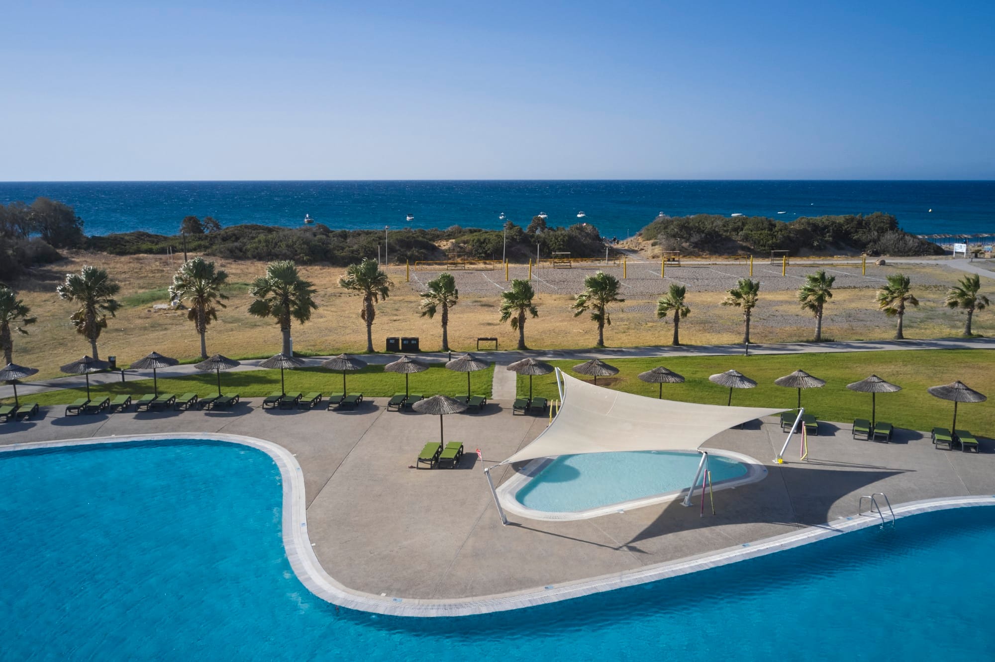 a pool with a beach and trees