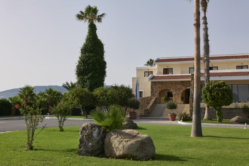 a building with a large lawn and trees in front of it