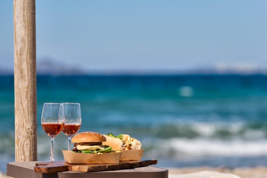 a table with food and glasses on it by the ocean