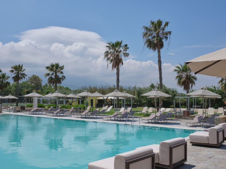 a pool with lounge chairs around it