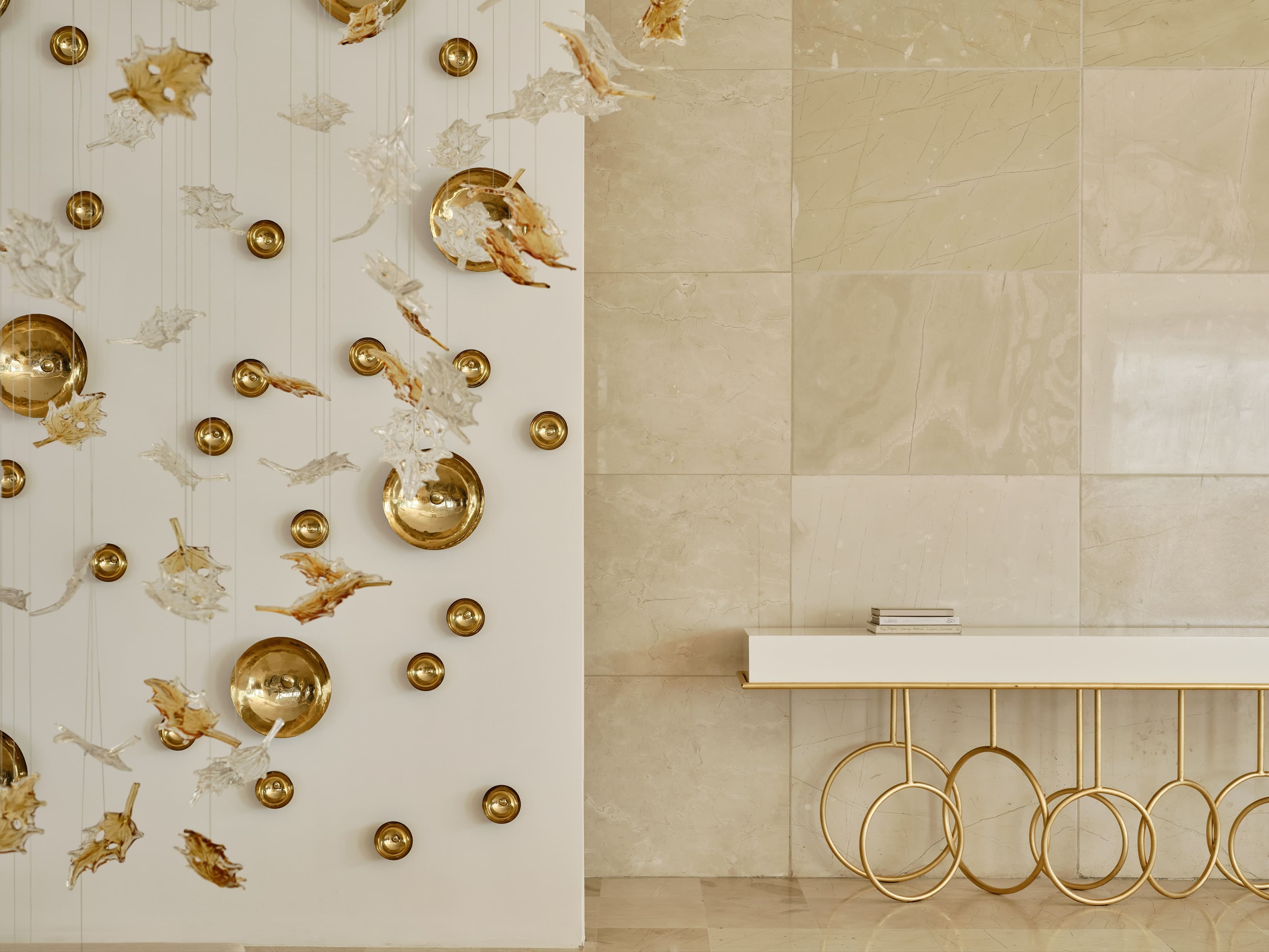 a white tiled bathroom with gold fixtures