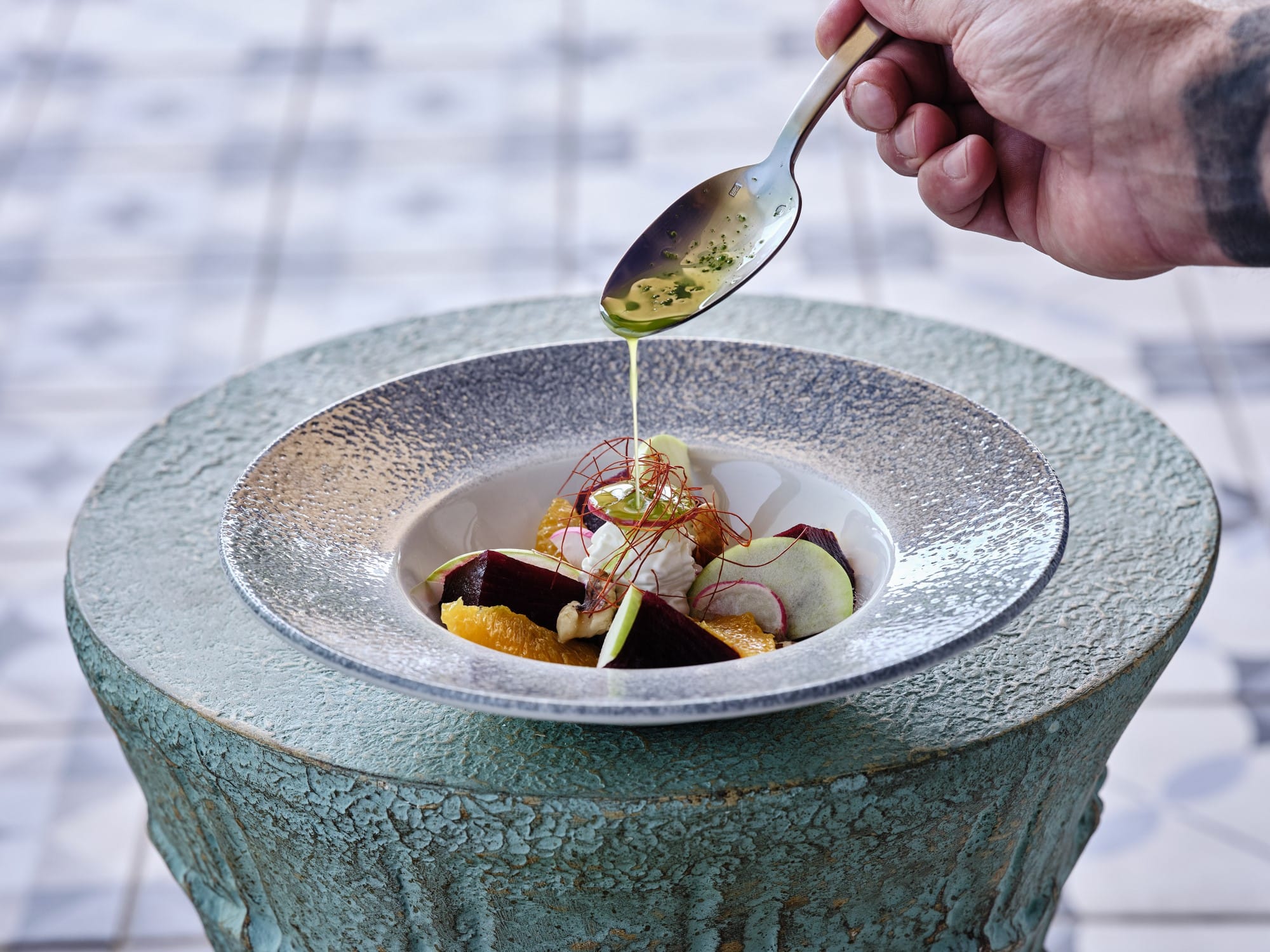 a person holding a spoon over a bowl of food