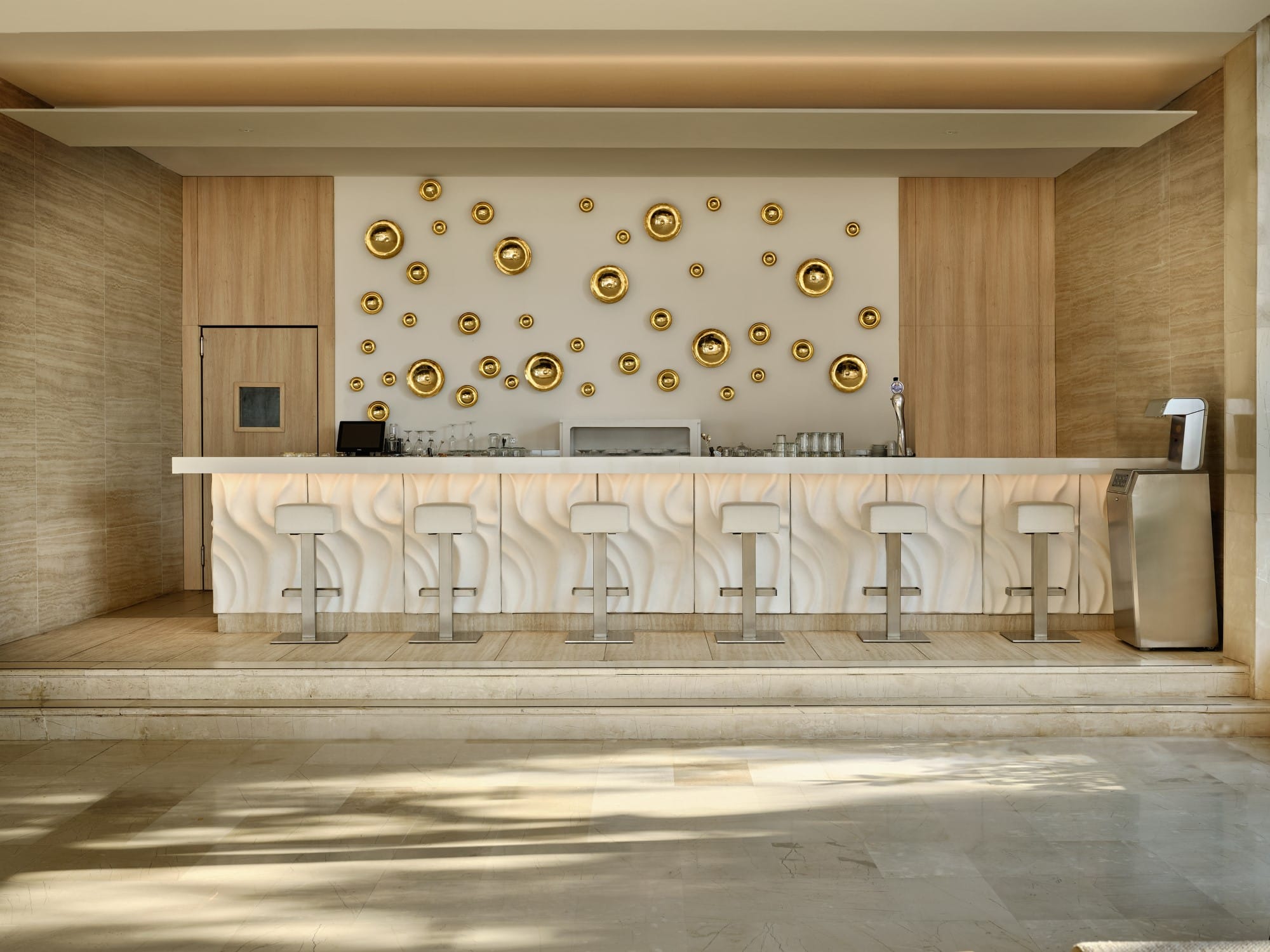 a large room with a bar and stools